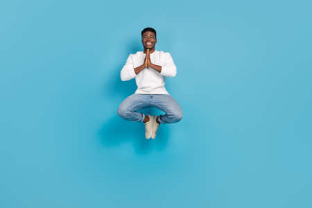 Full size portrait of handsome guy hands plead meditate isolated on blue color backgroundの写真素材