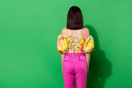 Photo of sweet slender girl dressed off shoulders standing back empty space isolated green color backgroundの写真素材