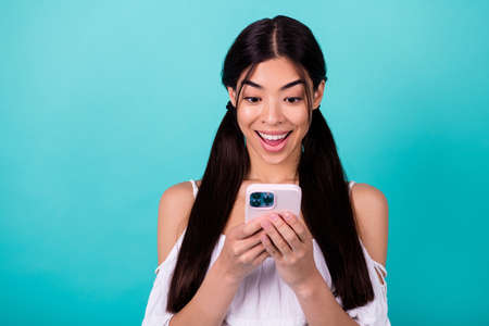 Photo of surprised millennial lady blogging network gadget web sale isolated on aquamarine color backgroundの写真素材