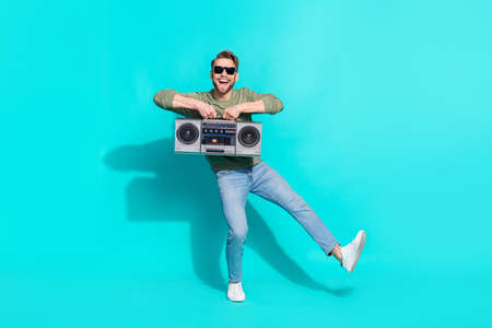 Full length photo of inspired energetic clubber man dance hold boom box have fun wear pullover isolated blue color backgroundの写真素材
