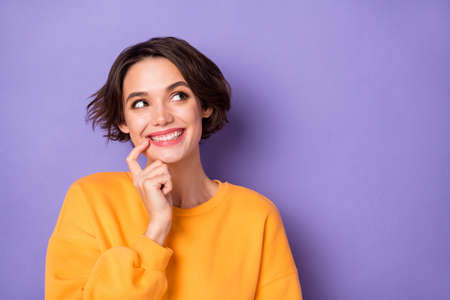 Photo of minded positive pretty girl finger touch lip look interested empty space isolated on violet color backgroundの写真素材