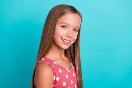 Photo of funny charming small girl wear pink dress smiling empty space isolated turquoise color...