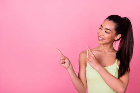 Photo of pretty shiny girl dressed yellow sarafan pointing looking empty space isolated pink color...