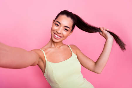 Photo of charming cute woman wear yellow dress recording self video isolated pink color backgroundの写真素材