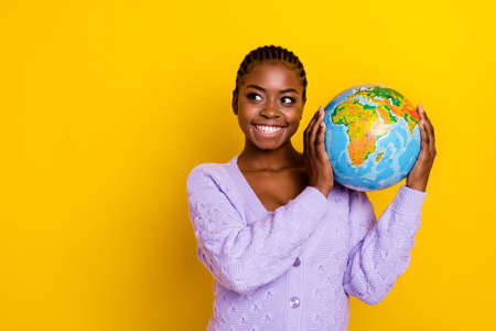 Photo of pretty positive lady hands hold globe look empty space isolated on yellow color backgroundの写真素材