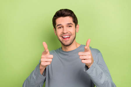 Photo of cool millennial brunet guy index camera wear grey cloth isolated on green color background