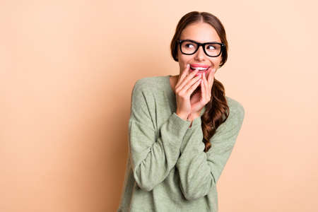 Photo of pretty funny girl dressed green pullover eyewear looking empty space isolated beige color backgroundの写真素材