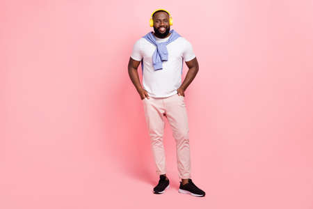 Full body photo of positive young man in elegant styled clothes go on walk listen favorite music...