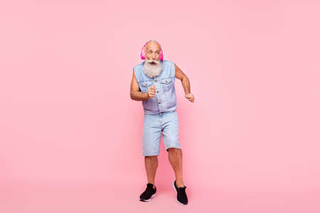Full length photo of dreamy funky retired guy wear jeans waistcoat earphones having fun isolated pink color backgroundの写真素材