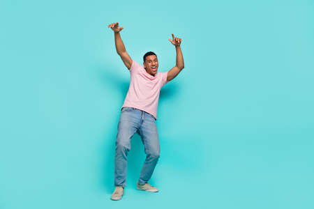 Full length photo of attractive sweet guy wear pink t-shirt dancing smiling isolated teal color...