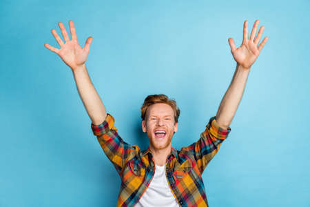 Photo of young crazy guy wear plaid shirt waiting sale favorite shop buy new clothes isolated on blue color backgroundの写真素材