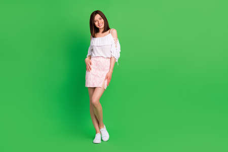 Full body photo of satisfied lovely person toothy smile posing empty space isolated on green color backgroundの写真素材