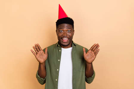 Photo of positive crazy guy wear cone headwear impressed incredible present isolated on pastel color backgroundの写真素材