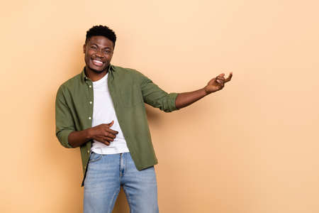 Photo of crazy youngster guy hand playing imaginary guitar performance concert isolated on pastel color backgroundの写真素材