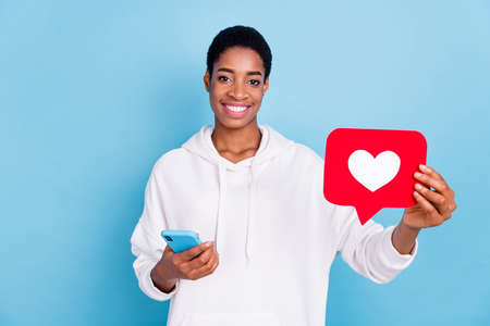 Photo of beautiful cute trans girl wear white sweatshirt chatting gadget holding heart sign isolated...