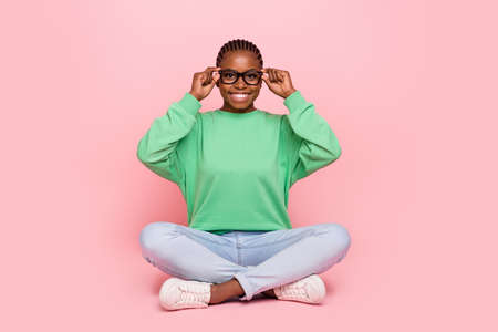 Full size photo of cheerful pretty girl sit floor hands touch glasses isolated on pink color backgroundの写真素材