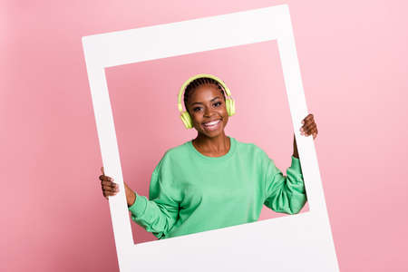 Photo of cheerful carefree girl hold paper window card toothy smile isolated on pink color backgroundの写真素材