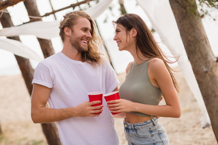 Photo of charming sweet husband wife smiling drinking cocktails having date outdoors countryside sea forestの写真素材