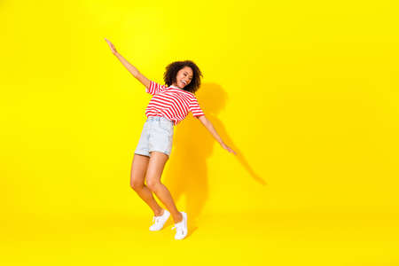 Full size photo of young smiling dancing lady hands wings looking empty space celebrating isolated...