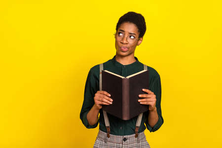 Portrait of attractive skeptic woman reading book materials thinking copy space isolated over bright...