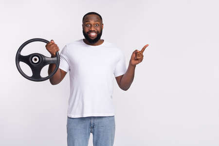 Photo of funny positive man wear casual t-shirt riding automobile pointing empty space isolated...