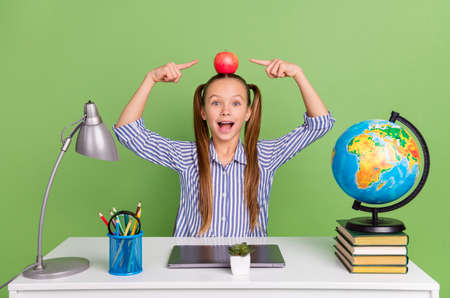 Photo of funky pretty small schoolkid dressed striped uniform tails holding head fruit sitting...