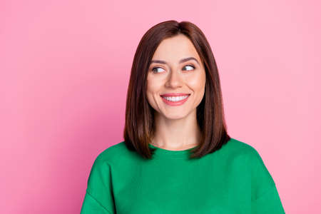 Closeup photo of young beautiful cute lady looking empty space smiling advertisement isolated on pink color backgroundの写真素材