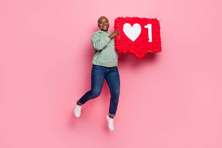 Full body image of pretty female jumping up with huge pinata like notification isolated on pink...