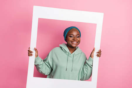 Photo of good mood woman wearing street style outfit hold big photo white frame isolated on pink...