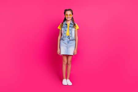 Full body photo of funky school blond girl stand wear glasses t-shirt vest skirt shoes isolated on fuchsia color backgroundの写真素材