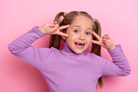 Photo of young little charming girl laughing showing v sign say hello to new friends in kindergarten...