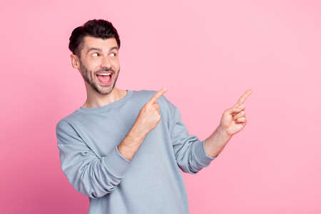Portrait of positive person toothy smile look direct fingers empty space isolated on pink color...