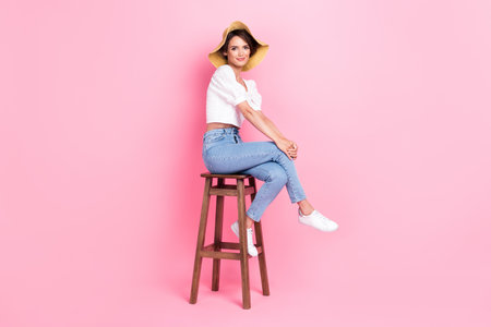 Full length photo of sweet shiny girl dressed white blouse cap sitting pool bar isolated pink color backgroundの写真素材