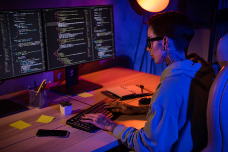 Profile portrait of experienced intelligent programmer girl sitting chair keyboard typing code workplace indoorsの写真素材