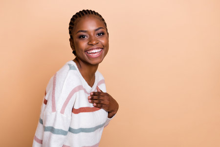 Photo of sweet braids hairdo millennial lady laugh wear striped sweater isolated on beige color backgroundの写真素材
