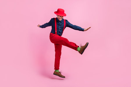 Full size portrait of handsome excited guy jumping have fun isolated on pink color backgroundの写真素材