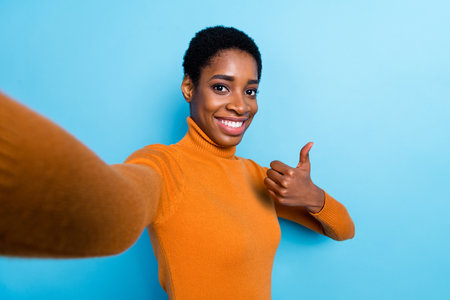 Close-up photo of young nonbinary identity blogger take selfie promote product isolated on blue color backgroundの写真素材