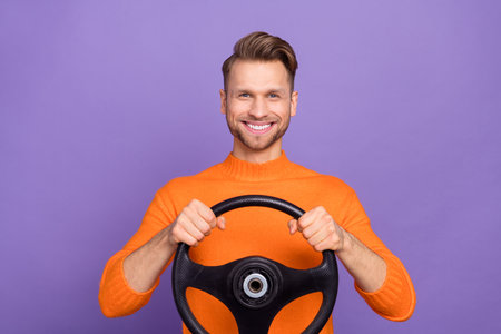 Photo of funky funny guy wear orange sweater driving car smiling isolated violet color backgroundの写真素材
