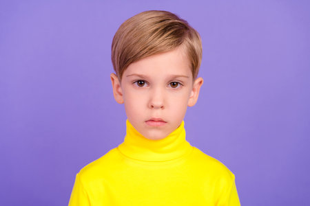 Portrait of calm focused school person look camera wear yellow pullover isolated on purple color backgroundの写真素材