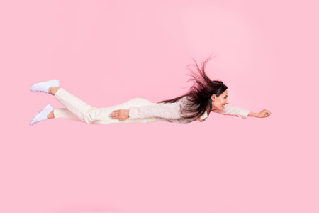 Profile side full length photo of inspired superwoman flying ahead levitating isolated on pastel...