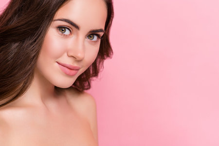 Cropped photo of young pretty woman lifting moisturizing fresh skin spa isolated over pink color backgroundの写真素材