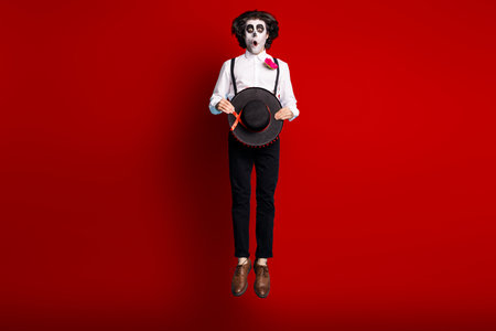 Full length body size view of his he handsome skinny tall creepy scary spooky amazed stunned gentleman jumping up catrina carnival celebratory isolated bright vivid shine vibrant red color backgroundの写真素材