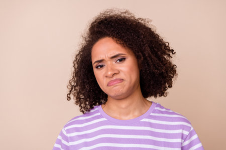 Photo of moody arrogant girl dressed purple t-shirt looking disgusting thing isolated beige color backgroundの写真素材
