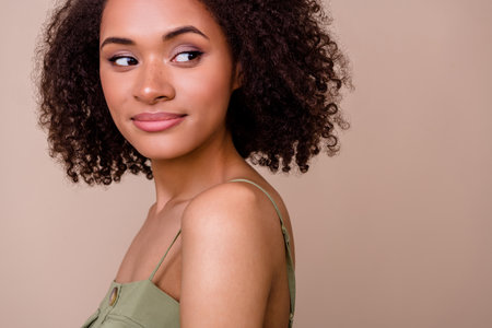 Close up photo of nice young lady wavy hair silky healthy skin empty space dressed stylish khaki garment isolated on beige color backgroundの写真素材