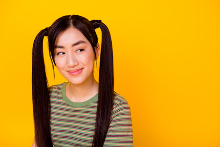 Portrait photo of young lovely pretty girl look empty space see shopping sales ad isolated on yellow color backgroundの写真素材