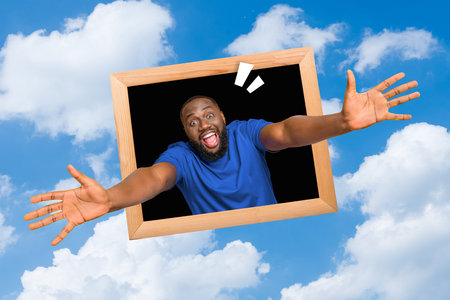 Composite collage image of excited cheerful guy inside wooden photo frame reach hands welcome you isolated on clouds sky backgroundの写真素材
