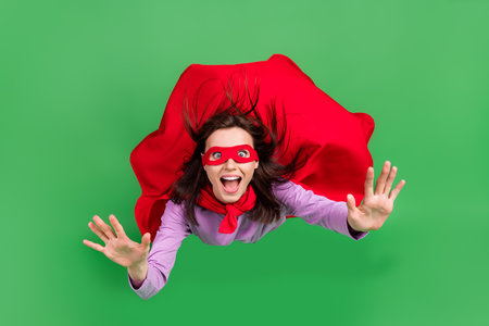 Full size photo of young funny face girl red mask cloak open mouth crazy reaction big sale black friday isolated on green color backgroundの写真素材