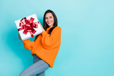 Portrait of gorgeous cheerful person hands hold giftbox look empty space isolated on teal color...
