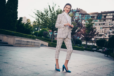 Full size photo of cheerful charming aged person posing hold sunglass walking street outsideの写真素材