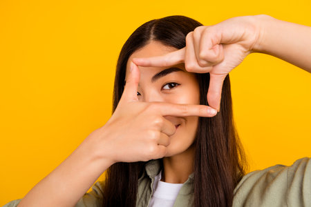 Close up photo of young creative skilled photographer make beautiful pictures isolated on yellow...
